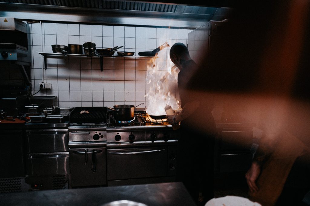 A kitchen staff cooking a dish inside a kitchen